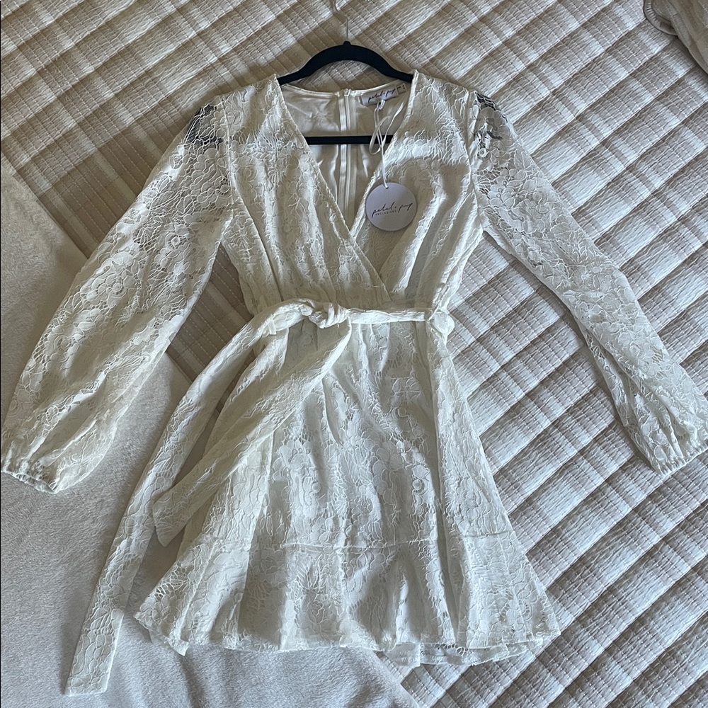 Elegant Lace Dress with tie waist a flare hem detail and button bust clasp.